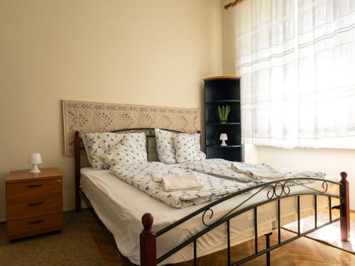 a bedroom with a bed and a window at City apartman with piano in Keszthely