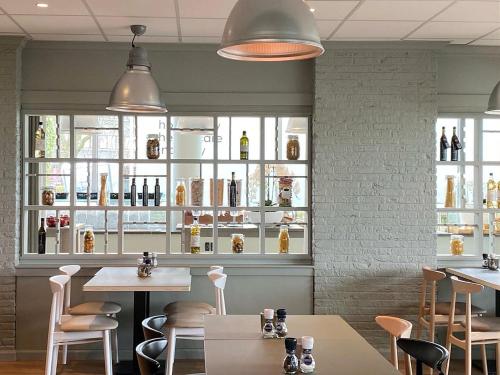 a restaurant with tables and chairs and shelves of wine bottles at Garner Hotel Maastricht by IHG in Maastricht