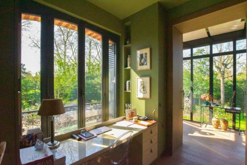 an office with a desk and windows with a view at Demeure Architecte avec Piscine Privee in Le Vésinet