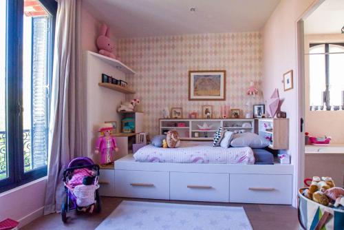 a childs bedroom with a bed and pink wallpaper at Demeure Architecte avec Piscine Privee in Le Vésinet