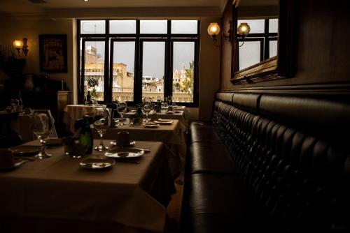 a row of tables in a restaurant with windows at Grand Hotel Tepatitlán in Tepatitlán de Morelos