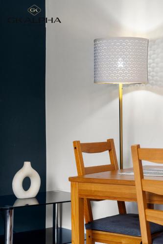 a dining room table with a lamp and a chair at 33A Castle Street - Contractor-Friendly 2-Bedroom Apartment in Reading City Centre with Wi-Fi, Parking & Long Stay deals in Reading