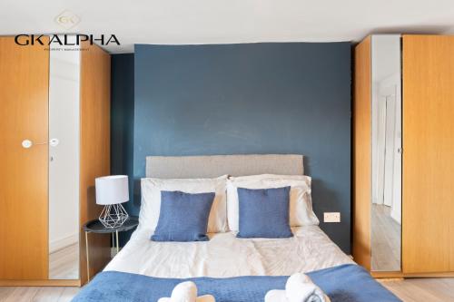 a bedroom with a large bed with two blue pillows at 33A Castle Street - Contractor-Friendly 2-Bedroom Apartment in Reading City Centre with Wi-Fi, Parking & Long Stay deals in Reading