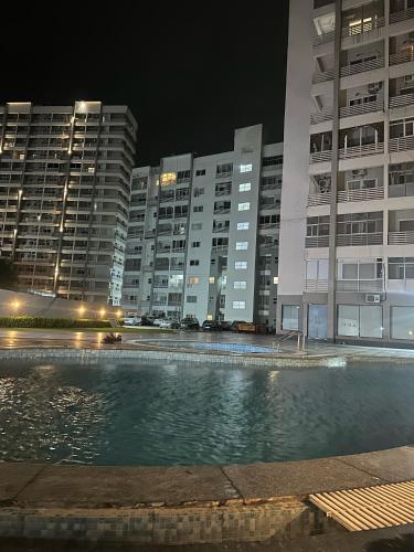 a swimming pool in front of some buildings at night at SUNSET STUDIOS Krishna heights! in Vrindāvan