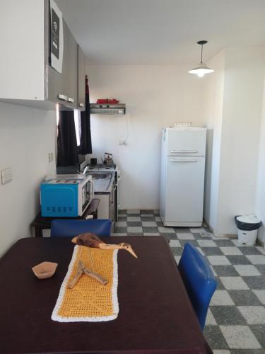 a kitchen with a table and a refrigerator at Cuesta de san miguel in Chilecito