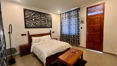 a bedroom with a bed and a table and a door at Domin Homestay in Arusha