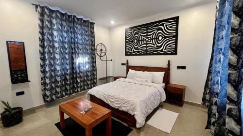 a bedroom with a bed and a painting on the wall at Domin Homestay in Arusha