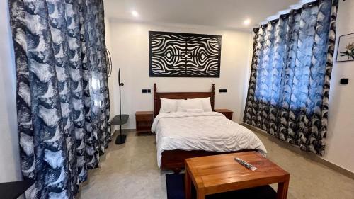 a small bedroom with a bed and a table at Domin Homestay in Arusha