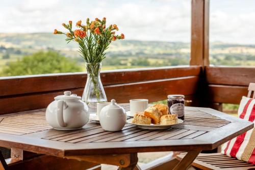 a table with a plate of bread and a vase with flowers at 1 Bed in Llandinam oc-t33065 in Llandinam