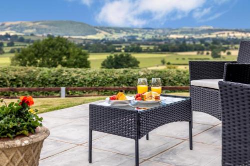 a table with a plate of food and two glasses of orange juice at 1 Bed in Llandinam oc-t33065 in Llandinam