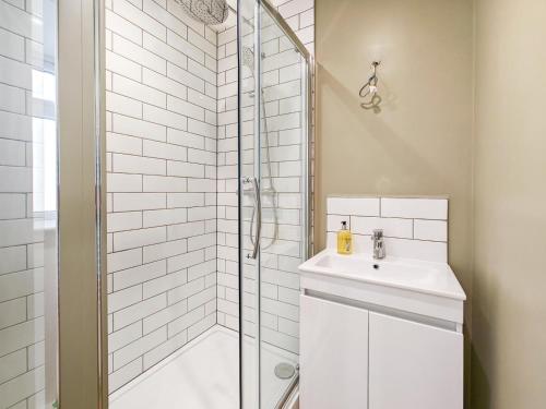 Un baño blanco con ducha y lavabo. en 2 Bed in Ventnor oc-e32619, en Ventnor