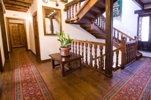 a living room with a staircase and a potted plant at Hospedaje Octavio in Santillana del Mar