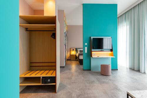 a room with a bed and a tv on a wall at Holiday Inn - the niu, Pax Berlin Airport by IHG in Berlin