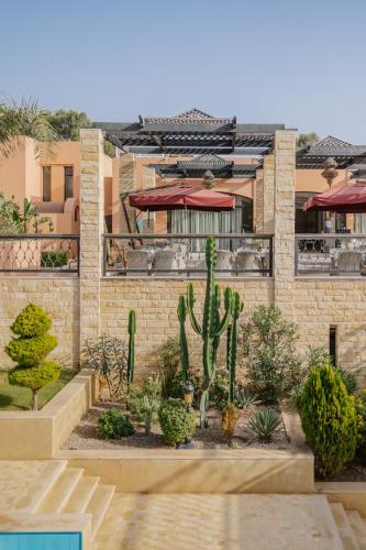 a garden in front of a building with a cactus at Hotel Prestige Agadir Boutique & SPA in Agadir