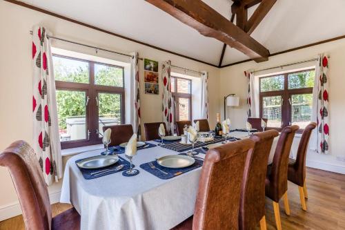 a dining room with a table and chairs and windows at 5 Bed in Clows Top oc-m32976 in Bayton