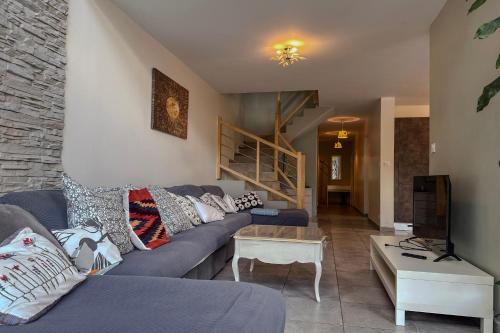 a living room with a blue couch and a table at L'étoile des Glaciers - Jacuzzi - Piscine - Hammam - ALPES HUEZ in Le Bourg-dʼOisans