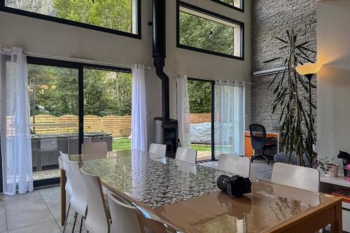 a dining room with a table and white chairs at L'étoile des Glaciers - Jacuzzi - Piscine - Hammam - ALPES HUEZ in Le Bourg-dʼOisans