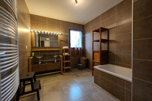 a bathroom with a tub and a sink at L'étoile des Glaciers - Jacuzzi - Piscine - Hammam - ALPES HUEZ in Le Bourg-dʼOisans