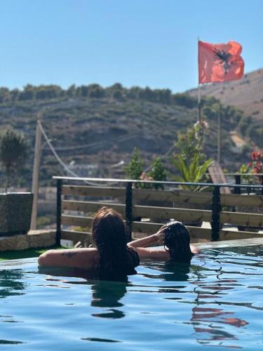 two people swimming in a pool of water at Saranda's Crown in Sarandë