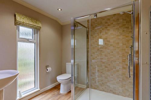 a bathroom with a toilet and a glass shower at 3 Bed in Two Waters Foot oc-r27336 in Cardinham