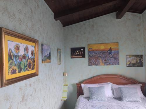a bedroom with a bed and pictures on the wall at I Santicelli in Morano Calabro