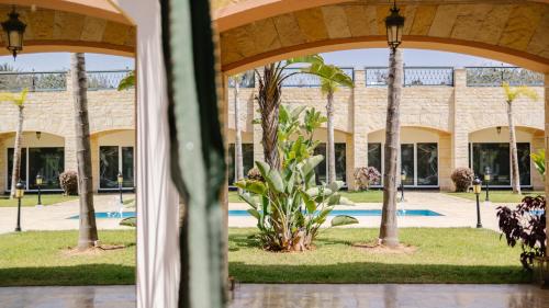 a view of the courtyard of a building with palm trees at Hotel Prestige Agadir Boutique & SPA in Agadir