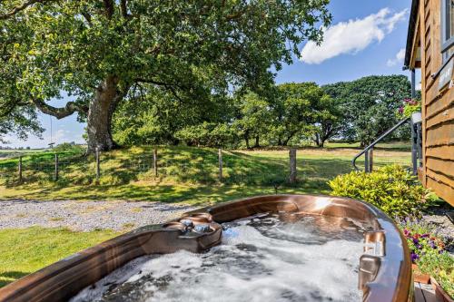 a hot tub in a backyard with a tree at 1 Bed in Llandeilo oc-w33068 in Llanddeusant