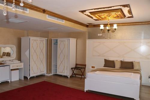 a bedroom with a white bed and a chandelier at Aksu Otel in Aliağa
