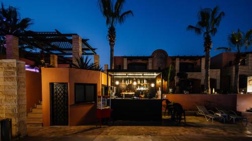 a building with a bar and palm trees at night at Hotel Prestige Agadir Boutique & SPA in Agadir