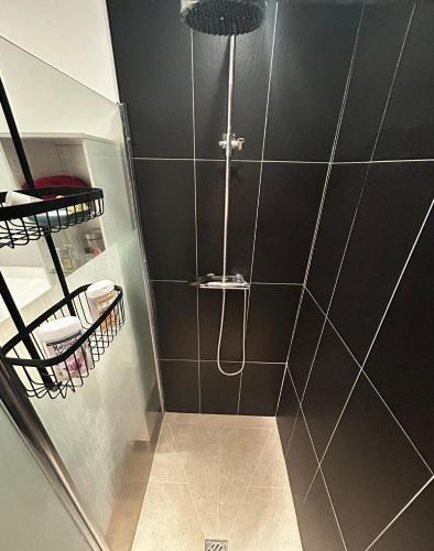 a bathroom with a shower with black walls and a shower at Chambre et petit déjeuner in Seclin