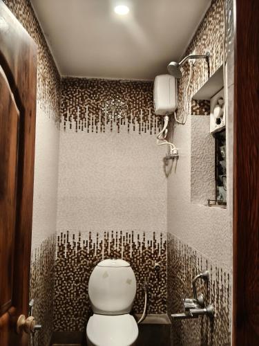 a bathroom with a toilet and a shower at Hotel Mahal in Uchalon