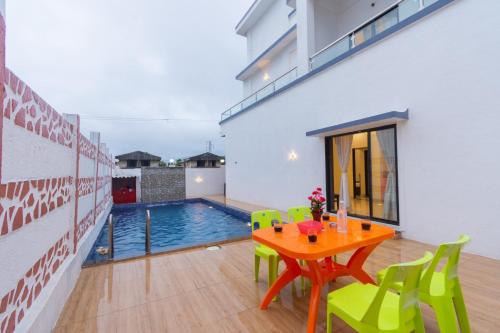 a dining room with a table and a swimming pool at Sanjana's villa in Malavli