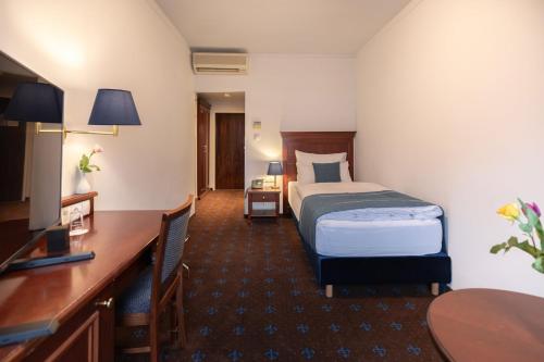a hotel room with a bed and a desk at Garner Hotel Vienna - Prinz Eugen by IHG in Vienna