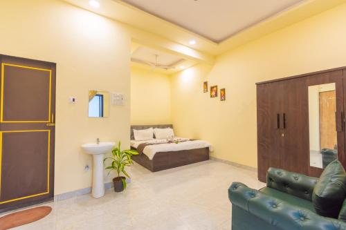 a room with a bed and a couch and a sink at Sanjana's villa in Malavli