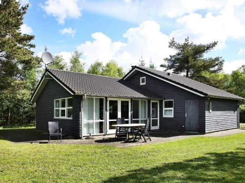 a black house with a picnic table in front of it at Tranquil Retreat near Golf - By Traum Ferienwohnungen in Bunken