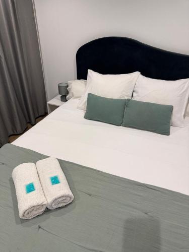 a bed with two towels sitting on top of it at LODGE INDIGO - Bungalow & RDC indépendant proche aéroport in Sainte-Marie