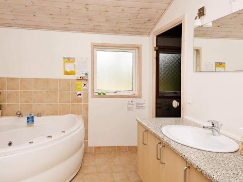 a bathroom with a large tub and a sink at Family Retreat in Lodskovvad - By Traum Ferienwohnungen in Hedensted - Nordjylland