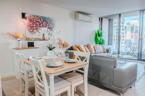 a living room with a table and a couch at Spencer Heights Stylish CBD Apartment 2BR 1Car in Melbourne