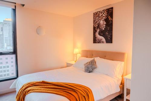 a bedroom with a bed and a picture on the wall at Spencer Heights Stylish CBD Apartment 2BR 1Car in Melbourne