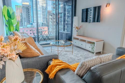 a living room with a couch and a table and a tv at Spencer Heights Stylish CBD Apartment 2BR 1Car in Melbourne