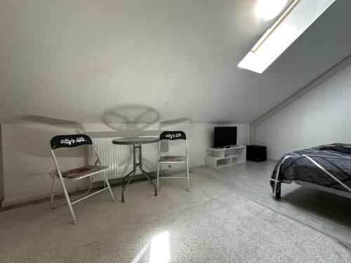 a bedroom with two chairs and a table and a bed at Vila ANA in Cluj-Napoca