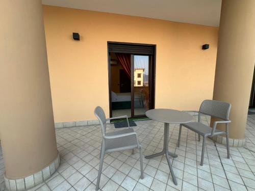 a patio with a table and chairs and a room at Oasi Urbana in Casoria