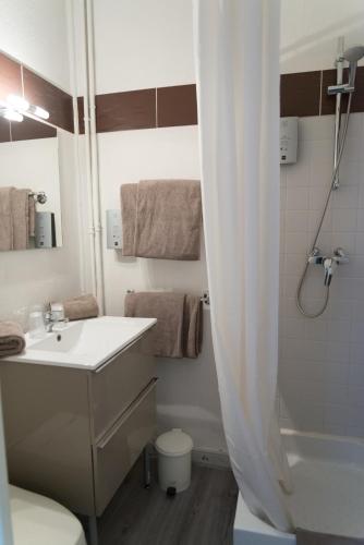 a white bathroom with a sink and a shower at Hotel Toppin in Cavaillon