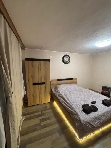 a bedroom with a bed and a clock on the wall at G Stone in Sliven