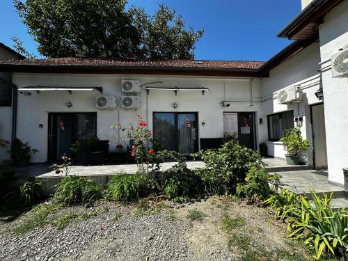 a white house with flowers in front of it at Vila ANA in Cluj-Napoca