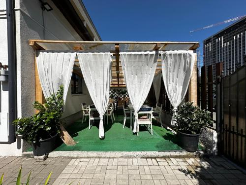 a patio with white curtains and a table and chairs at Vila ANA in Cluj-Napoca