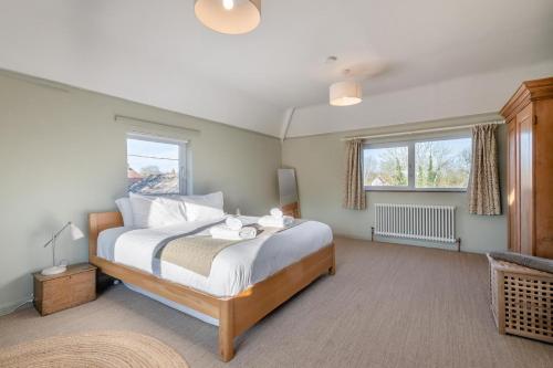 une chambre avec un grand lit et deux fenêtres dans l'établissement The Mill House, à Hindolveston