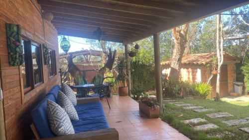 a patio with a blue couch on the side of a house at Refugio Santa Elena in Santa Elena