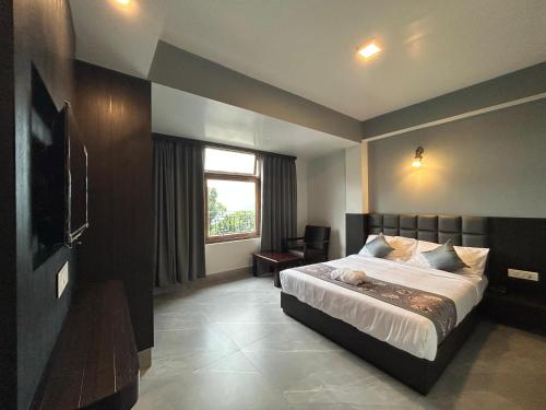 Un dormitorio con una cama grande y una ventana. en The Calyx, en Gangtok
