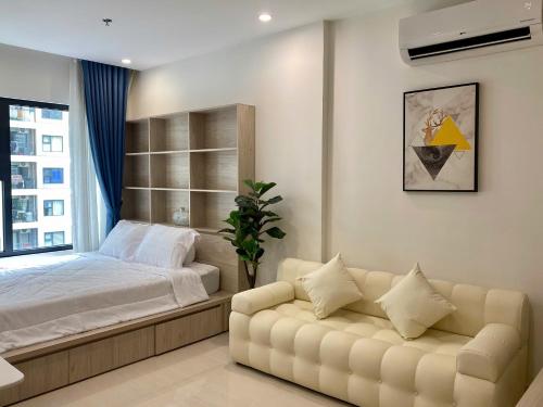a bedroom with a bed and a couch at Shi House - Studios S601 Origami Cozy Comfortable in Long Bình